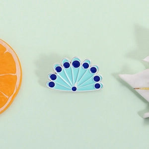 Peacock feather enamel pin in blue and green hues with a vibrant fanned-out design