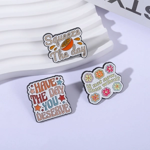 Set of 3 enamel pins featuring creative orange, star, and flower motifs with slogans