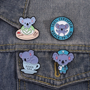 Set of four cute koala enamel pins including nurse and coffee themes on denim jacket