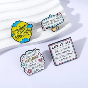 Lot de quatre broches en émail coloré avec des slogans inspirants et citations en anglais