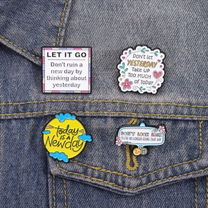 Lot de 4 épingles en émail inspirantes avec citations sur veste en jean bleu