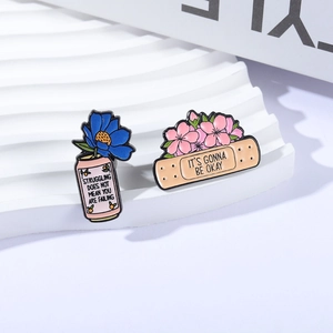 Inspirational floral enamel pins set featuring motivational quotes on a white stand
