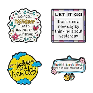 Set of four colorful inspirational enamel pins with motivational quotes on white background