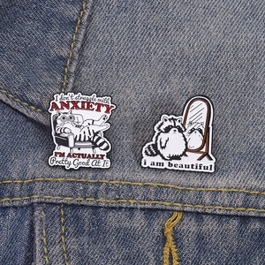 Grappige emaille spelden met angstige kat en wasbeer op blauwe denim stof set