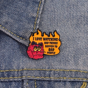 Broche en émail chat diabolique avec flammes sur fond en tissu denim bleu foncé