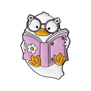 Cute cartoon duck enamel pin wearing glasses and reading a purple book for decoration