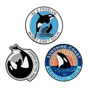 Set of three unique enamel orca pins with nautical illustrations and slogans