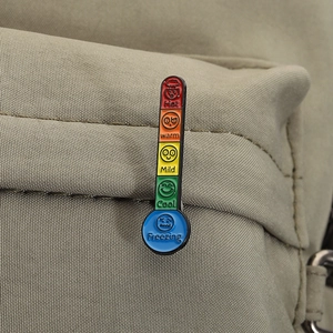 Detail of creative thermometer enamel pin with colorful temperature levels and expressions