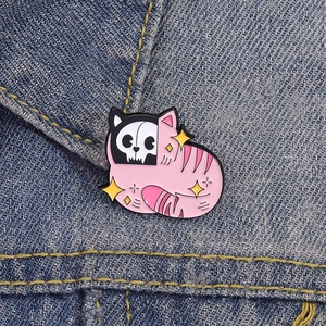 Rosa Katzen und schwarze Totenkopf Emaille Anstecknadel auf Jeansjacke im Dark Gothic Style
