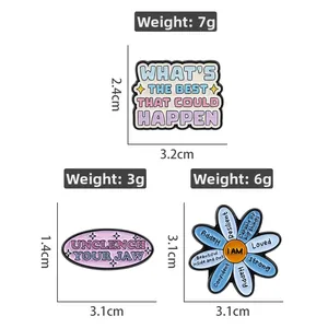 Detailed view of three enamel pins with motivational quotes and dimensions shown