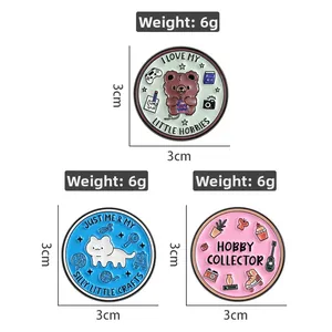 Detailed close-up of three circular enamel pins featuring cute animals and hobby collector motifs