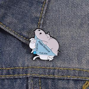 Funny math pun enamel pin featuring hippopotamus and cats on denim fabric backdrop