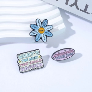 Creative enamel pin set with positive affirmations and floral designs on a wavy stand