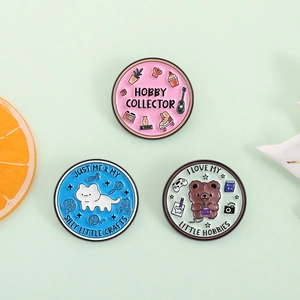 Trois pin's en émail animaux avec slogans de loisirs sur fond vert pastel doux