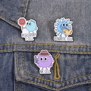 Emaille-Pins mit Immunzellen-Motiven auf Jeansjacke, inklusive T-Zelle und NK-Zelle