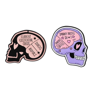 Pink and purple skull enamel pins with creative existential crisis and snacks lettering