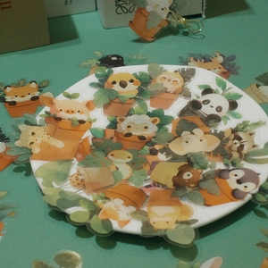 Pile of waterproof cartoon animal plant stickers in a dish for journal decoration