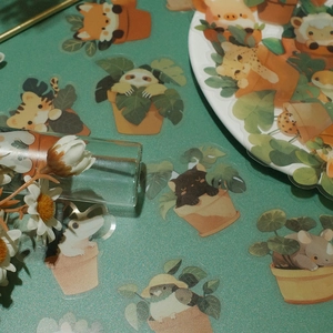 Detail of waterproof PET stickers featuring cute cartoon animals in potted plant designs