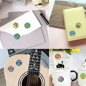 Rouleau d'autocollants animaux sur une enveloppe, un carnet, une guitare et une tasse