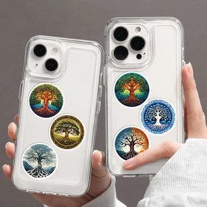 Two transparent iPhone cases featuring diverse Tree of Life art stickers on a grey background