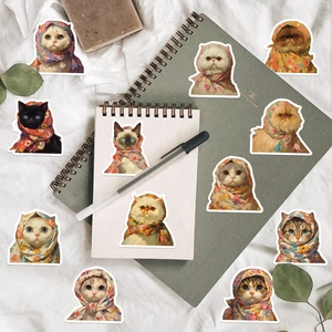 Plano cenital de lindos adhesivos de gatos babushka en un cuaderno con papelería