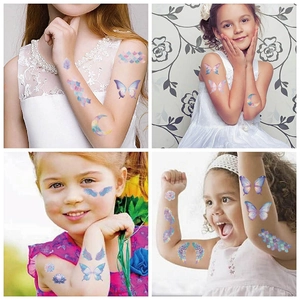 Close-up of waterproof butterfly and mermaid temporary tattoos on child's arm and face