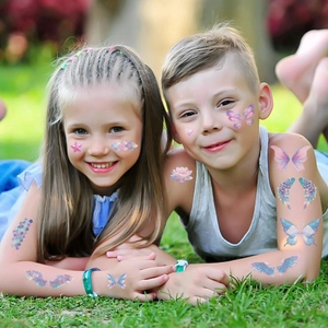 Vibrant butterfly and mermaid temporary tattoos applied to child's face and arms for parties