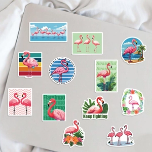 Waterproof flamingo stickers on a silver laptop with tropical plants and motivational text