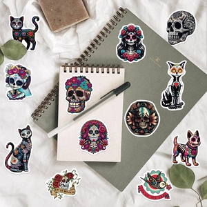 Flat lay of Day of the Dead stickers with sugar skulls and marigold patterns on a notebook