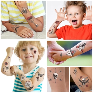Detailed application of dark skull and butterfly temporary tattoos on child's arm and face