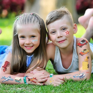 Gros plan d'enfants portant des tatouages éphémères de véhicules colorés dans un parc
