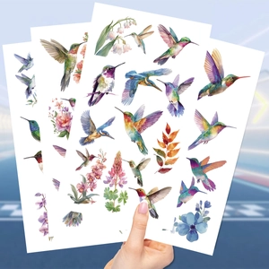 Primo piano di tre fogli di tatuaggi temporanei impermeabili con colibrì e fiori acquerello