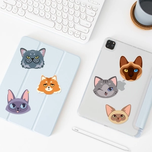 Macro shot of cute cartoon cat stickers on a tablet case with a minimalist white desk setup