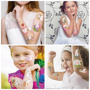 Nahaufnahme bunter Oster-Tattoos für Kinder mit Hasen- und Ei-Motiven auf dem Arm