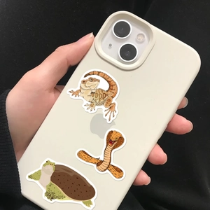 Close-up of waterproof cartoon reptile stickers applied on a white smartphone case