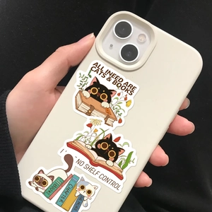 Close-up of cute cartoon cat and book stickers applied to the back of an off-white phone case