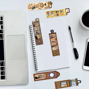 Detailed view of cat illustration bookmarks placed on a desk with laptop and coffee