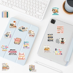 Cartoon cat and book stickers decorating a tablet and case on a desk with accessories