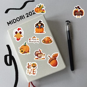 Detailed view of colorful Thanksgiving turkey and pumpkin stickers on a notebook