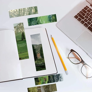Macro shot of nature-themed bookmarks featuring forest, mountain and lake scenic designs
