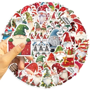 Primo piano dell'adesivo impermeabile dello gnomo di Natale tenuto in mano sopra altri adesivi