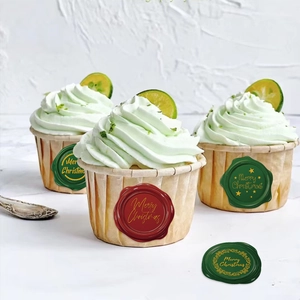 Christmas wax seal stickers in red and green with gold Merry Christmas lettering on gift cups
