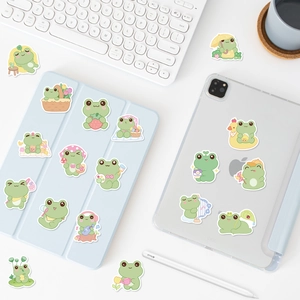 Detail of cute frog stickers on tablet and stylus showing various artistic cartoon poses