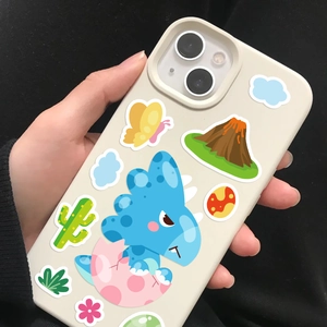 Close-up of a cream iPhone case featuring cute cartoon dinosaur and volcano illustrations