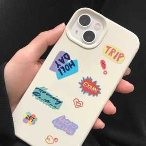 Détail de la coque iPhone crème avec des autocollants graffiti motivants colorés