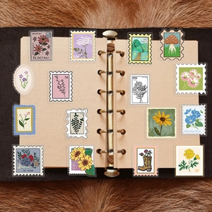 Gros plan détaillé d'autocollants timbres floraux rétro sur un carnet vintage de DIY