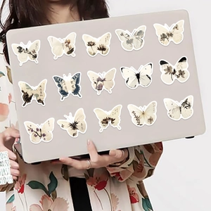 Detalle de pegatinas de mariposas en estilo de tinta china sobre un ordenador portátil