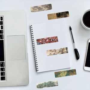 Detail of traditional Chinese art bookmarks featuring landscape and calligraphy on a desk