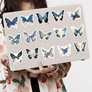 Detalle de pegatinas de mariposas de tinta sobre una computadora portátil plateada