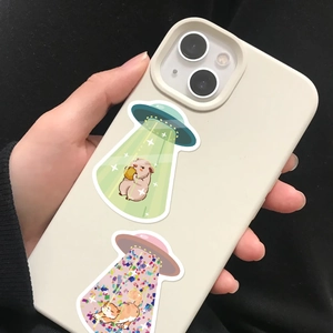 Detailed view of cartoon UFO abduction stickers featuring a hamster and an orange cat